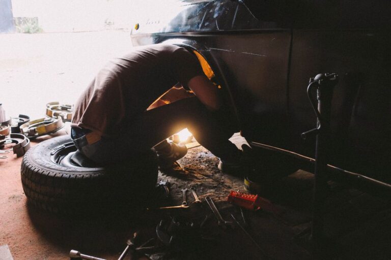 A professional automotive technician working on the rear of an engine block to perform a rear main seal replacement